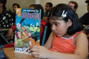 Little girl reading comic book